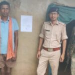 फरार आरोपी के घर पुलिस द्वारा इश्तेहार चिपकाते अधिकारी
